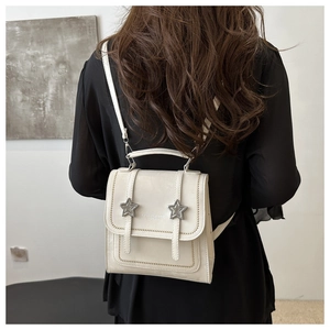 Detail of cream vintage mini backpack with silver star buckles on faux leather