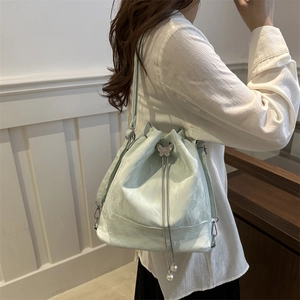 Hellgrüne Beuteltasche mit Silber-Schmetterling und Perlen-Kordelzug am Modell