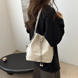 Elegante cremefarbene Beuteltasche mit Schmetterlingsschnalle und Perlendetails