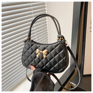 Vue détaillée du sac à main en cuir PU matelassé noir avec un nœud doré en métal