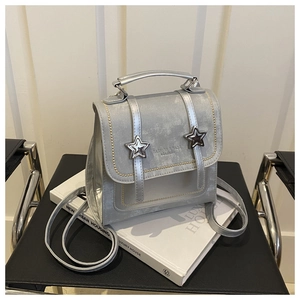 Close-up of metallic silver mini backpack with star buckles and fashion leather engraving