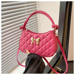 Détail du sac à main rose fuchsia matelassé avec un nœud doré en relief et finitions