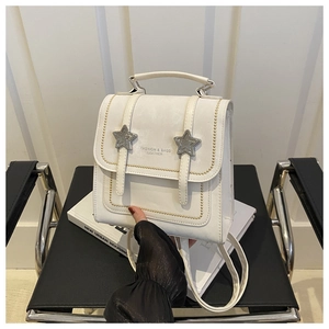 Detail of white vintage leather backpack with silver star buckles and gold stitching