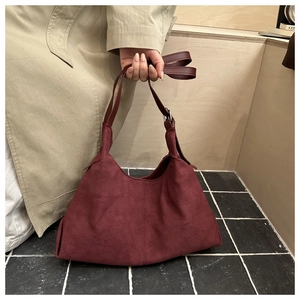 Detail of burgundy suede hobo bag with stitching and smooth leather shoulder strap