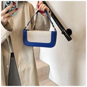 Dettaglio della borsa baguette blu e beige con finta pelle e patchwork di tessuto