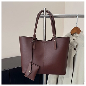 Detail of a dark brown large tote bag with matching flap pouch pendant on a hanger