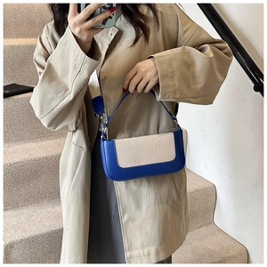 Piccola borsa quadrata color-block indossata da una modella in un trench kaki