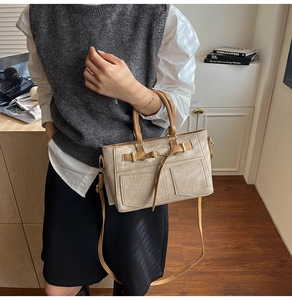 Dettaglio borsa beige in ecopelle retrò con fibbie dorate e tasche decorative