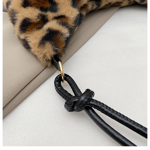 Detailed close-up of leopard print faux fur bag with black leather knotted strap and gold hardware
