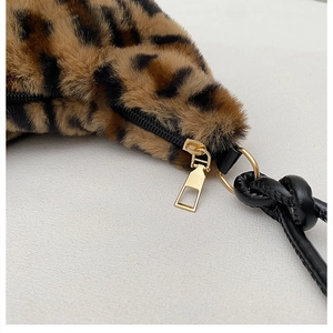 Close-up of leopard print faux fur texture with gold zipper and leather strap detail