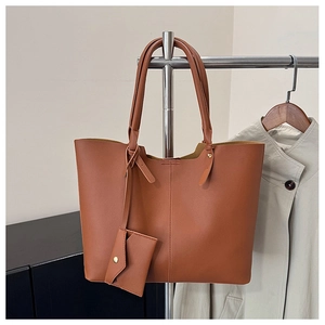 Detail view of large brown tote bag with leather texture on a metal hanger