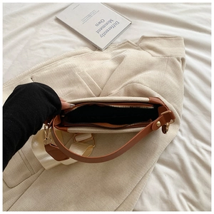 Top view of beige canvas crossbody bag showing interior lining and leather strap details