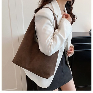 Commuter look showing a large dark brown suede tote bag styled with a white blazer
