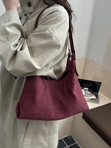 Chic burgundy suede tote bag for women worn by a model with a beige trench coat