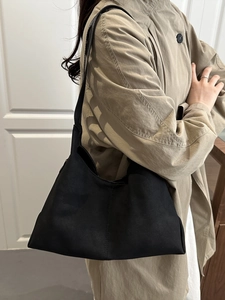 Chic black matte hobo shoulder bag styled with a trench coat for daily casual commute