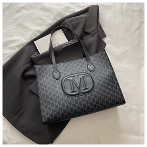 Close-up of Harajuku style tote bag with M-letter monogram print and textured leather