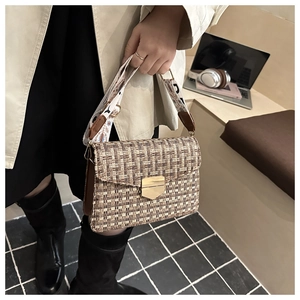 Detail of tweed crossbody bag featuring a golden buckle and ethnic jacquard strap