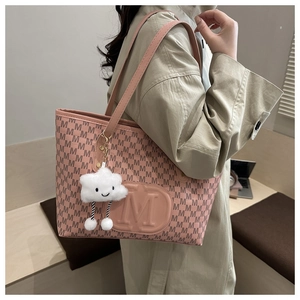 Détail d'un sac cabas rose matelassé avec motifs M et charm nuage mignon sur le côté
