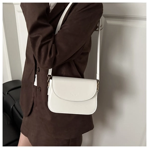Close-up of a white leather crossbody square bag with Fashion Bags print on a suit