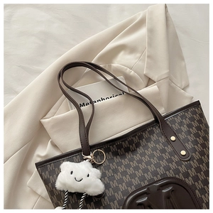Détail du sac cabas marron avec motif lettre M et charm peluche nuage blanc amovible