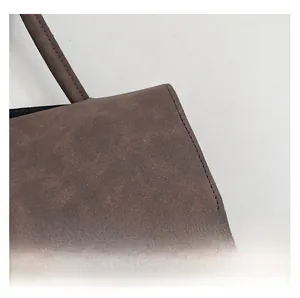 Detail showing high-quality stitching and matte brown suede texture on a tote bag