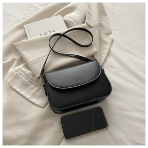 Detail of black matte leather crossbody bag with phone for size reference and stylish finish