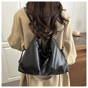Vue détaillée du sac en cuir noir montrant sa grande capacité et son fini brillant
