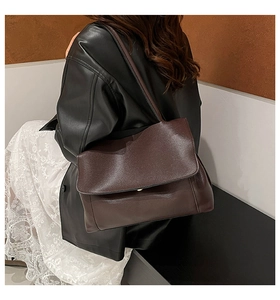 Detail of soft dark brown lychee grain leather shoulder bag with flap closure
