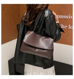 Brown faux leather flap shoulder bag styled with a long strap and casual outfit
