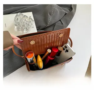Donkerbruine geweven crossbodytas met ruime opbergruimte voor smartphone en lippenstift