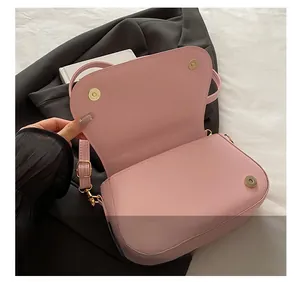 Detail view of pink PU leather bag featuring a gold magnetic buckle and adjustable strap