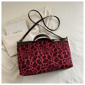 Close-up of leopard and rose print tote bag with premium leather handles and gold logo