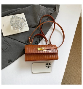 Détail du tissage du sac marron en cuir avec smartphone pour comparaison de taille