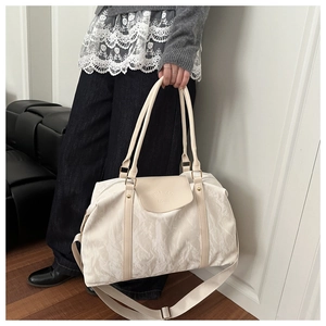 Detail of beige large capacity pillow bag with embossed HUA JIAO FASHION logo and texture