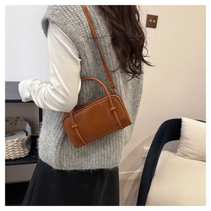 Brown retro PU leather handbag shown on model featuring decorative knots and slim strap