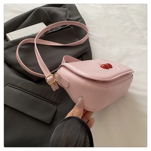 Detail of pink leather handbag with cherry ornaments and gold metal buckle on strap