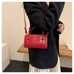 Detail of red PU leather bag with embossed fashion text and dual handle design