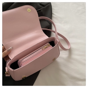 Detail of pink PU leather flap bag featuring removable zipper pouch and gold magnetic clasp