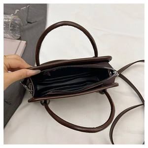 Interior view of brown PU leather handbag showing spacious main compartment and zip pocket