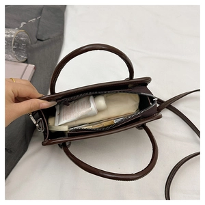 Internal view of the brown leather handbag showing main compartment and zipper storage
