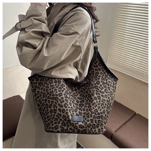 Leopard print tote bag styled with a beige trench coat on a fashion model shoulder