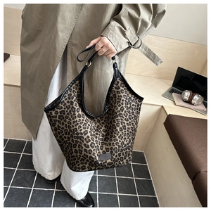 Détail d'un sac cabas en toile à imprimé léopard avec bordures en cuir noir et grande taille