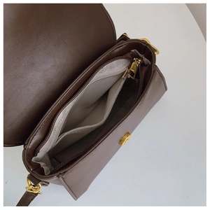Détail de l'intérieur du sac marron foncé avec poche zippée et fermoir magnétique doré