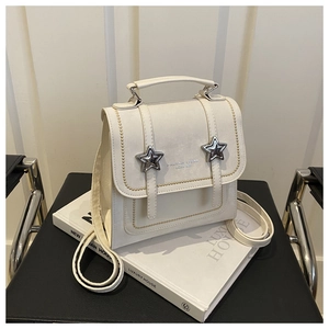 Close-up of cream backpack with silver star studs and yellow wave stitching details