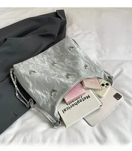 Detail of silver metallic tote with butterfly charms showing spacious interior capacity