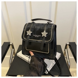 Detail of vintage black bag with silver stars, gold rivets and matte leather texture