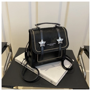 Detail of black matte leather mini bag with silver star studs and metal rivets on the flap
