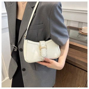 Chic cream white leather shoulder bag with gold metal buckle shown on a female model