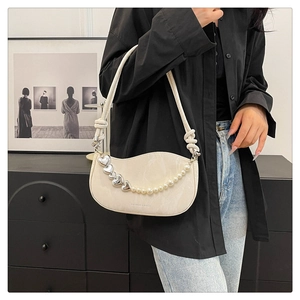 Detail of creamy white underarm bag with marble texture and heart pearl chain detail