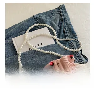 Detail of pink corduroy bucket bag with red strawberry print and pearl bead handle